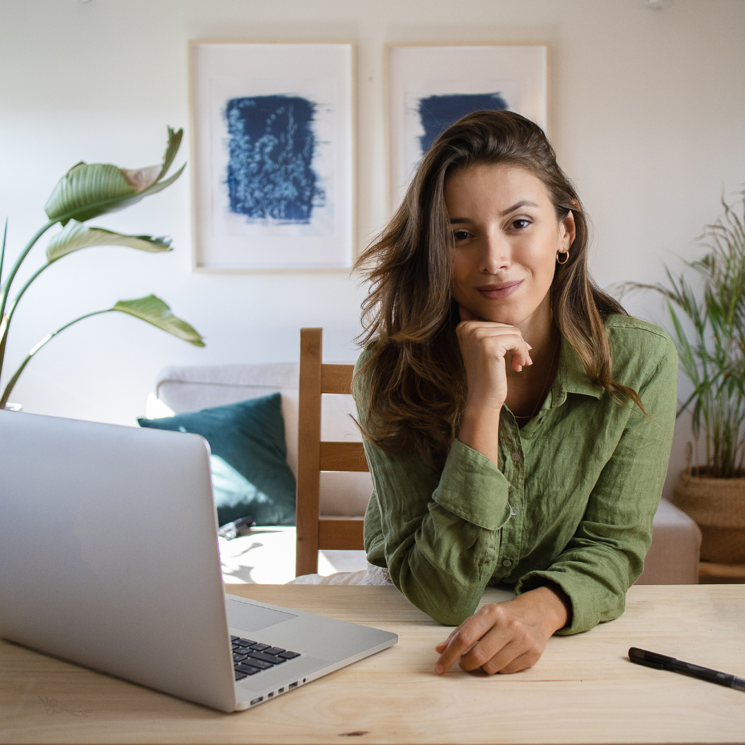 Female entrepreneur working from home looking at the camera with laptop